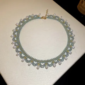 Handgemaakte lichtblauwe kralen choker ketting met druppelparels en goudaccenten