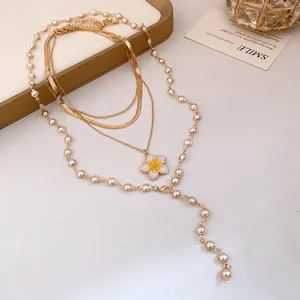 Collana vintage a strati dorati con un delicato ciondolo a fiore giallo e perle chic