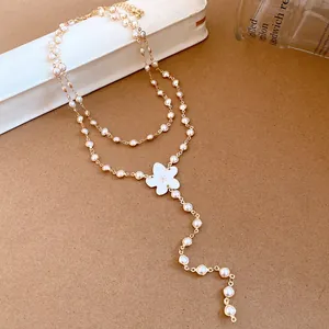 Elegant double-layered pearl necklace featuring a delicate white flower pendant detail.