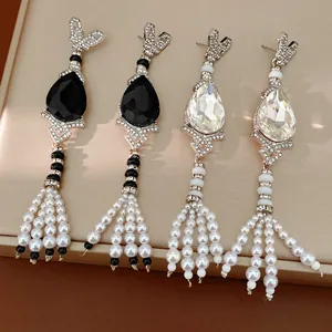 Detailed macro shot of vintage waterdrop earrings with pearl tassels and rhinestones.