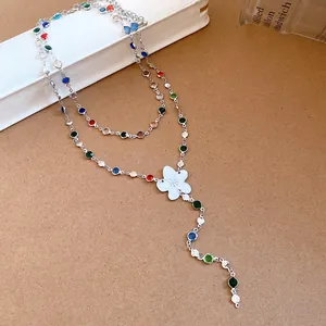 Close-up of a chic silver necklace featuring vibrant resin beads and a white floral charm.