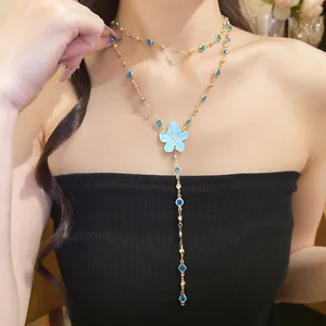 Detailed view of a gold-toned necklace featuring blue resin flowers and blue rhinestones.