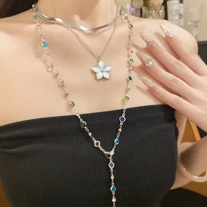 Dettaglio di una collana vintage multistrato con ciondolo a fiore e perline colorate.