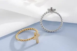Detail view of twisted rope stainless steel rings with cross charms in gold and silver