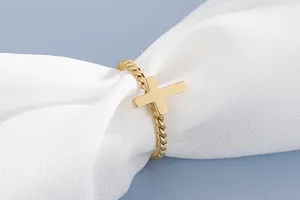 Detailed close-up of a gold stainless steel twisted band ring featuring a smooth cross charm