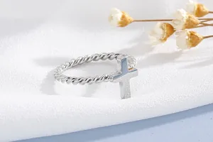 Detailed close-up of a silver stainless steel twisted wire ring with a cross element.