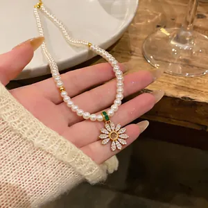 Detailed macro shot of 18k gold plated pearl necklace with zircon flower pendant