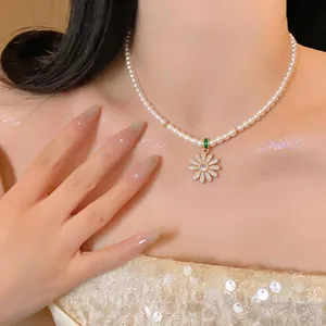 Close-up of elegant pearl necklace with zircon daisy pendant on model