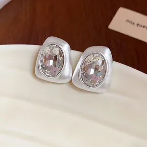 Detailed view of elegant silver geometric stud earrings with faceted oval crystal centers
