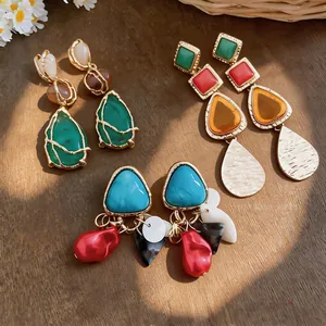 Pendientes colgantes geométricos de estilo vintage con detalles de resina y metal.