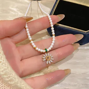 Detailed macro view showing the sparkling zirconia flower pendant and delicate pearls