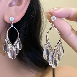 Close-up detail of silver resin teardrop tassel earrings with a clear finish