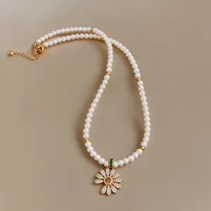 Close-up view of an elegant 18k gold plated flower pearl necklace with sparkling zirconia stones