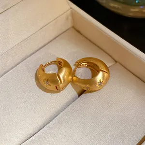 Detailed macro view of vintage gold hoop earrings with engraved starburst pattern