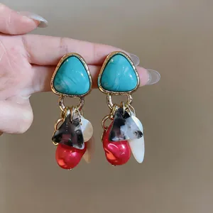 Primer plano detallado de pendientes geométricos vintage con colgantes de concha y perlas de moda