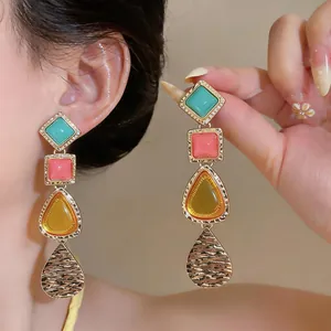 Primer plano detallado de pendientes colgantes geométricos vintage de colores