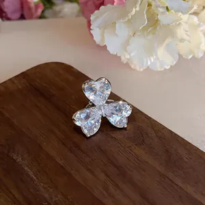 Macro view of elegant heart-shaped zircon flower ear clip on a rustic wooden board