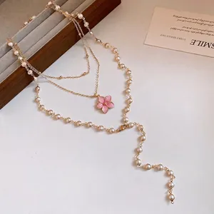 Elegante mehrlagige Goldhalskette im Bohème-Stil mit rosa Blumenanhänger und weißen Perlen