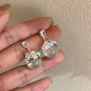Detailed view of crystal stud earrings with colorful flowers and clear resin balls