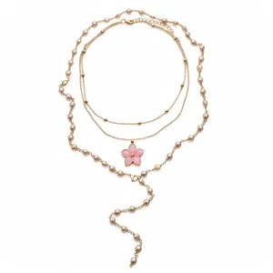 Elegante mehrlagige Perlenkette mit einem rosa Blumenanhänger und goldfarbenen Kettendetails