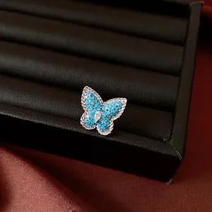 Elegant butterfly ear clip with blue stones and marquise zircon on black display tray