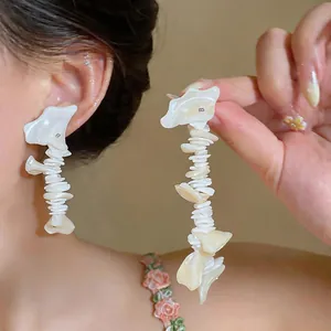 Detailed close-up of French style shell tassel earrings with iridescent finish