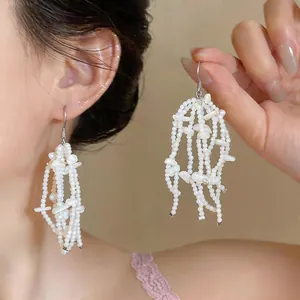 Close-up of elegant French style white shell fringe earrings worn by an Asian model.