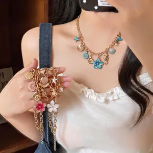 Vintage vacation style necklace with gold shell seahorse and flower charms for women