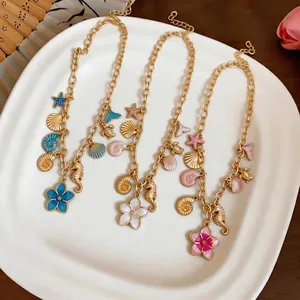 Elegant gold necklace with ocean charms including shells seahorses and flowers for women