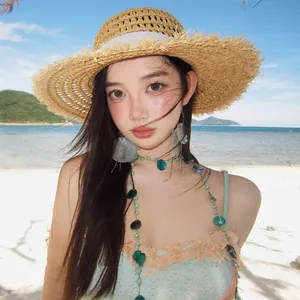 Close-up of bohemian shell necklace and oversized earrings worn by model at the beach