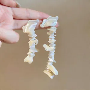 Close-up detail of French style long shell tassel earrings with natural pearl luster