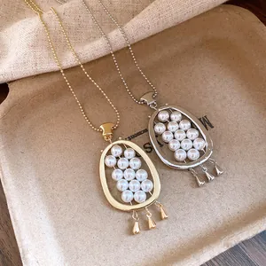 Detailed view of vintage gold and silver oval necklaces with pearls and teardrop charms