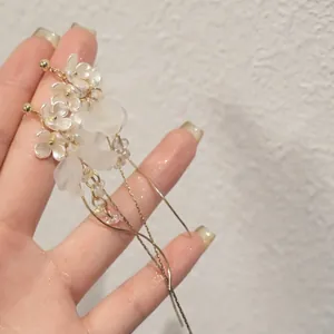 Gros plan détaillé de boucles d'oreilles à pompons fleuris chic de style français