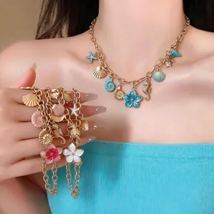 Exquisite detail of gold chain necklace and bracelet with seashell and seahorse charms