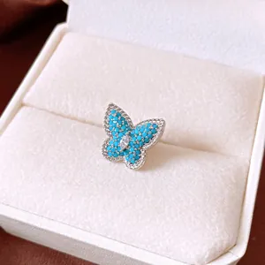 Exquisite detail view of a turquoise butterfly ear clip with marquise zircon in a box