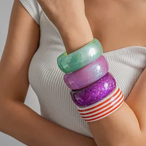Close-up of colorful resin dopamine style bangles with stripes and glitter