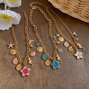 Close-up of ocean-themed gold chain necklaces with seahorse and seashell pendants