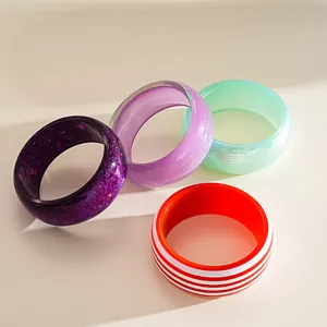Detail shot of colorful dopamine style resin bangles featuring glitter and stripes