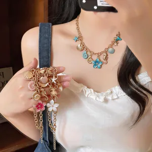 Close-up of vintage ocean-themed necklace with shell and flower charms