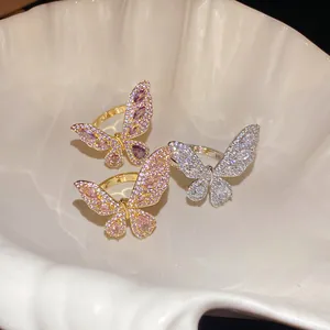Dettaglio di anelli a farfalla con zirconi incastonati in tonalità oro e argento