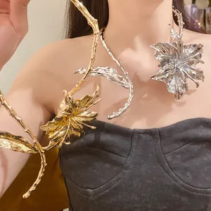 Detail view of an artistic gold and silver metallic flower and leaf collar necklace.