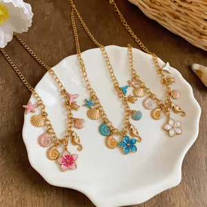 Detailed macro view of gold sea-themed necklaces with shell and flower pendants