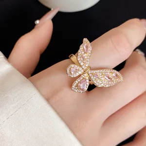 Dettaglio dell'anello a farfalla dorato con micro pavé di zirconi rosa e bianchi.