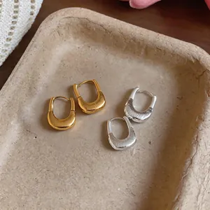 Detail view of 18K gold plated U-shaped earrings with unique crumpled metal texture