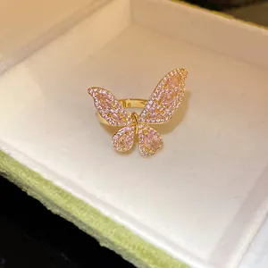 Vista dettagliata di un anello aperto a farfalla con zirconi rosa in finitura dorata