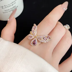 Primo piano di un elegante anello a farfalla in oro con zirconi viola micro-set