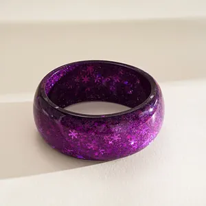Detailed view of fashionable purple resin bangle with glitter and snowflake pattern inserts