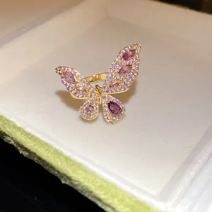 Primo piano di un anello a farfalla dorato con pietre di zirconia viola