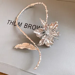 Detailed close-up of a silver metallic floral choker featuring a pleated flower design