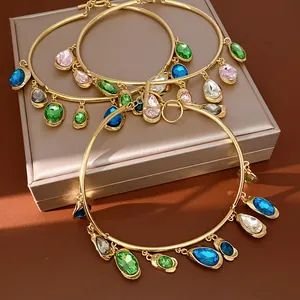 Detailed view of gold statement chokers with multi-colored teardrop crystal charms